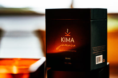 Moody image of Kima coffee packaging with warm candle light